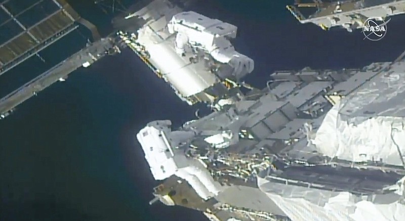 In this image taken from NASA video, NASA astronauts Kate Rubins, top, and Victor Glover work outside the International Space Station Sunday, Feb. 28, 2021. Thespacewalking astronauts ventured out Sunday to install support frames for new, high-efficiency solar panels arriving at the International Space Station later this year. (NASA via AP)