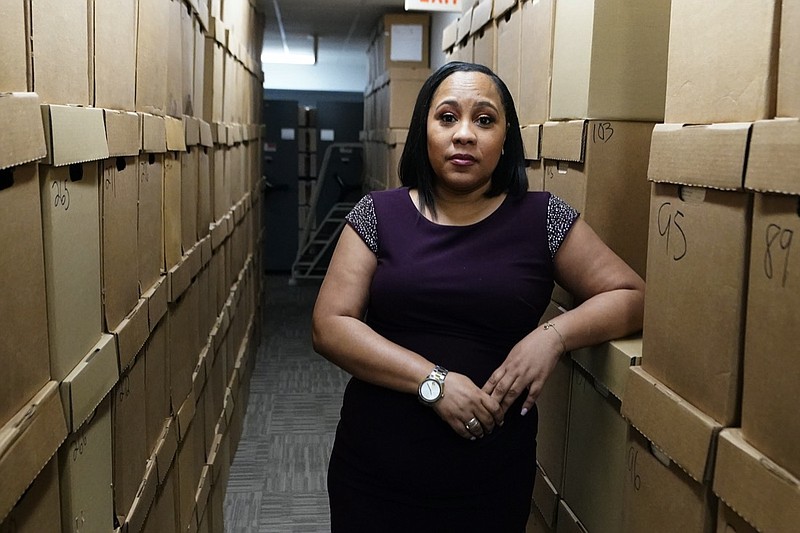 Fulton County District Attorney Fani Willis poses among boxes containing thousands of primal cases at her office, Wednesday, Feb. 24, 2021, in Atlanta. (AP Photo/John Bazemore)