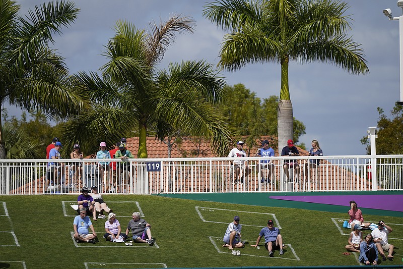 Fans sit in social distance squares during a spring training baseball game with the Minnesota Twins and Boston Red Sox on Sunday, Feb. 28, 2021, in Fort Myers, Fla. (AP Photo/Brynn Anderson)