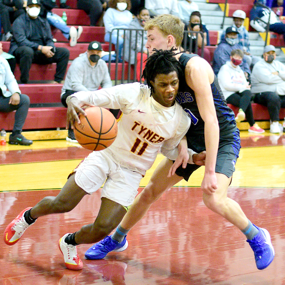 Staff Photo by Robin Rudd / Tyner's Keilan Holloway (11) drives to the basket and is fouled by Red Bank's Taylor Swanson (0). The Tyner Rams hosted the Red Bank Lions in the boy's TSSAA Region 3-AA Tournament Semifinals on March 2, 2021.