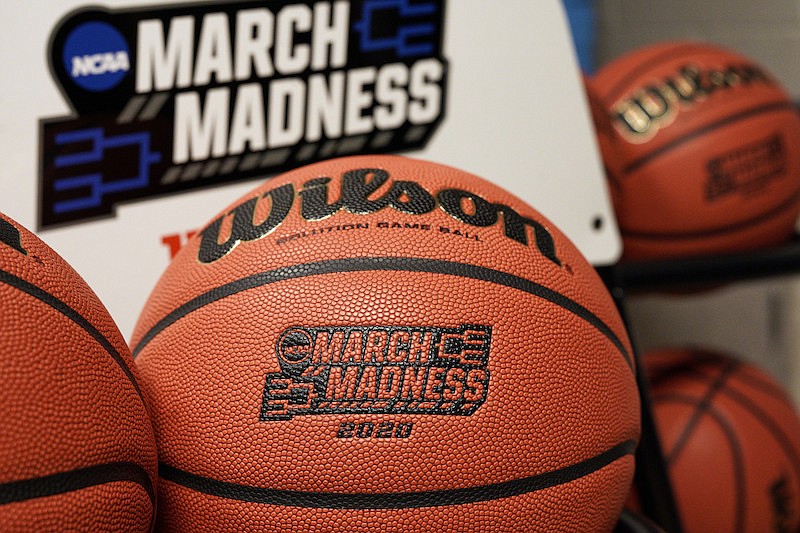 In this March 16, 2020, file photo, official March Madness 2020 tournament basketballs are displayed in a storeroom at the CHI Health Center Arena, in Omaha, Neb. The dominos started tumbling in March, when the NCAA abruptly called off March Madness, given no choice but to forgo a nearly $800 million TV payment that helps keep the entire college sports machine running. (AP Photo/Nati Harnik, File)