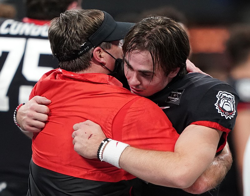Photo by Jason Parkhurst / This embrace between coach Kirby Smart and quarterback JT Daniels after Georgia's 24-21 topping of Cincinnati in the Chick-fil-A Peach Bowl on New Year's Day seemed unlikely this time last year, when Daniels had yet to even transfer to Athens.