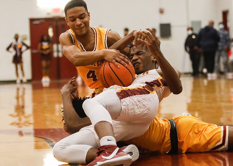 Staff photo by Troy Stolt / Howard's Jadon Jenkins, top, and Tyner's Trent Gresham fight for a loose ball during the Region 3-AA boys' basketball championship Thursday night at Tyner. The host Rams won 53-49.