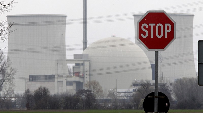 FILE - In this March 18, 2011 file photo, a traffic sign stands next to the nuclear power plant of Biblis, Germany. The German government said Friday it has agreed with four utility companies that they will receive a combined 2.4 billion euros ($2.9 billion) in compensation for the early shutdown of their nuclear power plants. (AP Photo/Michael Probst, file)