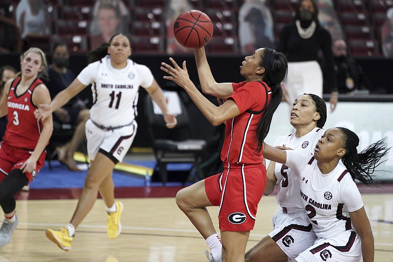 AP photo by Sean Rayford / Georgia's Mikayla Coombs shoots as South Carolina's Eniya Russell, right, and Victaria Saxton trail her on Jan. 21 in Columbia, S.C., where the host Gamecocks won 62-50. The teams meet again Sunday in the SEC tournament title game in Greenville, S.C.