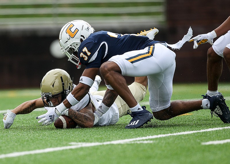 Staff photo by Troy Stolt / UTC defensive back Jelen Lee (37) and Wofford running back D'mauriae VanCleave scramble for the ball after VanCleave fumbled a punt during the teams' SoCon game Feb. 27 at Finley Stadium.