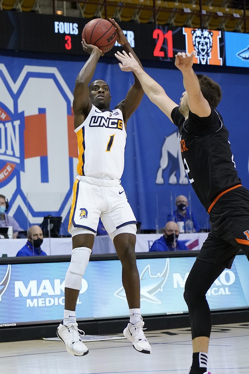 UNC-Greensboro guard Isaiah Miller (1) shoots for the basket over Mercer forward Felipe Haase (22) in the first half of an NCAA men's college basketball championship game for the Southern Conference tournament, Monday, March 8, 2021, in Asheville, N.C. (AP Photo/Kathy Kmonicek)
