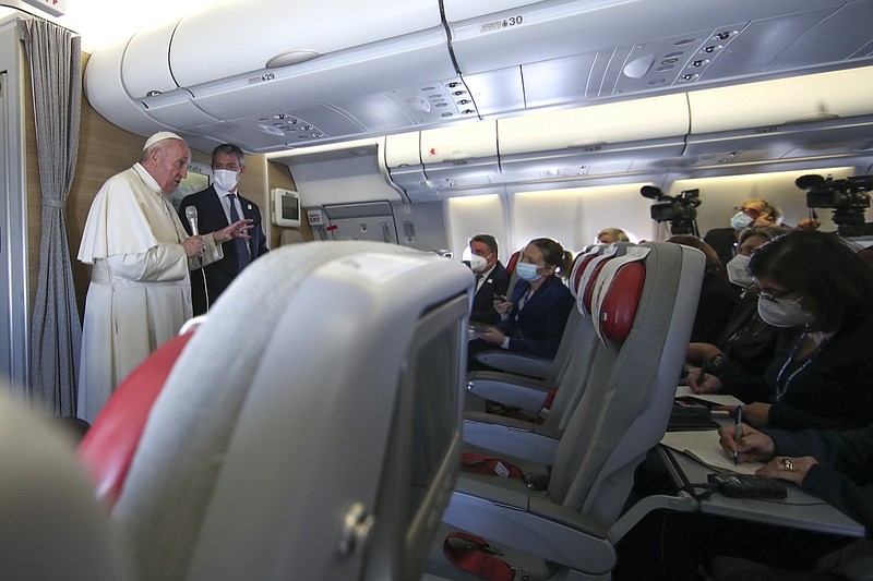 Pope Francis speaks to journalists, Monday, March 8, 2021, while flying back to The Vatican at the end of his four-day trip to Iraq where he met with different Christian communities and Shiite revered cleric Grand Ayatollah Ali al-Sistani. (AP Photo/Yara Nardi, pool)

