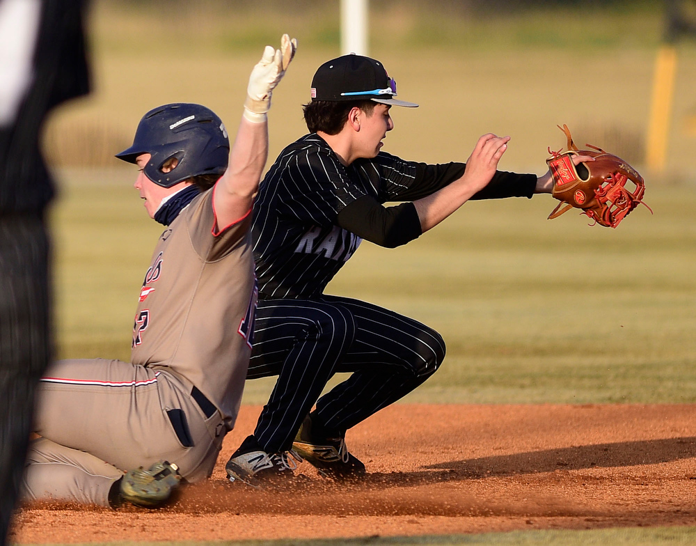Staff Photo by Robin Rudd / Heritage's Alex Mixon (12) slides safely into second as Southeast shortstop, Johnny Vega (1) takes the throw. The Heritage Generals hosted the Southeast Whitfield Raiders in GHSA basely on March 9, 2021.