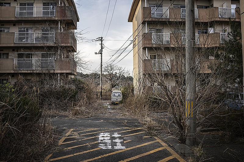 Weeds grow in a still-abandoned apartment complex in Futuba, the town closest to the nuclear meltdown site in Japan's Fukushima Prefecture, March 4, 2021. Ten years after a devastating earthquake, tsunami and nuclear meltdown, those who have returned are readjusting to places that feel familiar and hostile at once. (James Whitlow Delano/The New York Times)