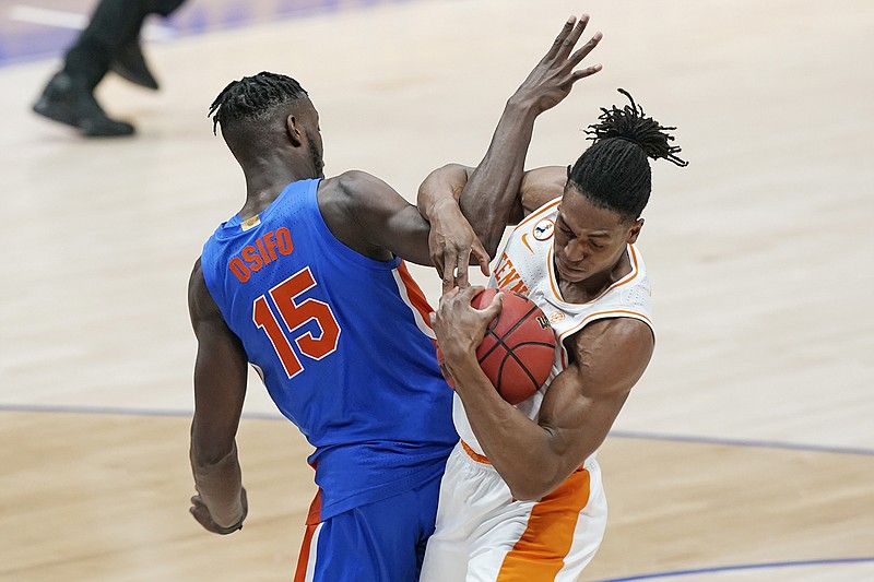 AP photo by Mark Humphrey / Florida's Osayi Osifo and Tennessee's Yves Pons get tangled in the first half of their teams' SEC tournament quarterfinal Friday afternoon at Bridgestone Arena in Nashville. Pons scored 11 points and had a program-record nine blocked shots to help the fourth-seeded Vols win 78-66, beating the Gators for the second time in six days and advancing to a Saturday semifinal against top-seeded Alabama.