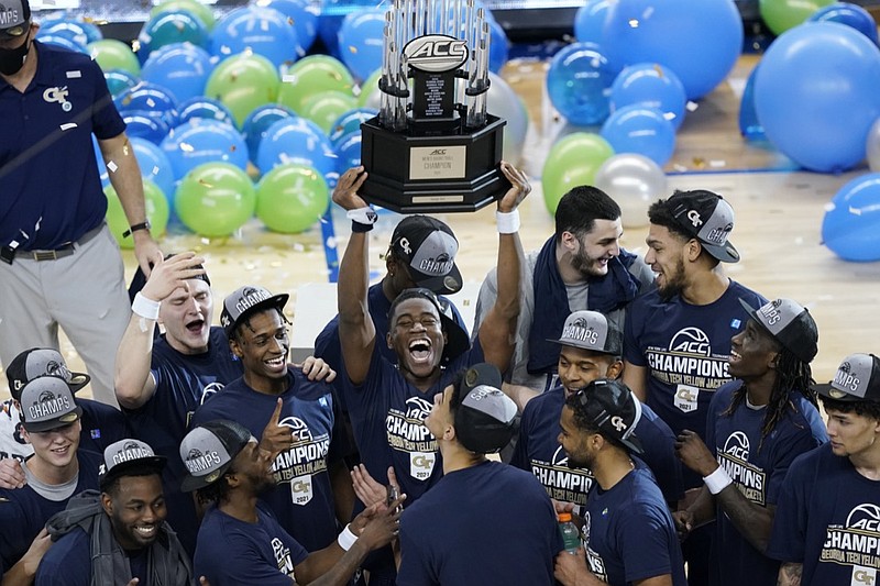 Georgia Tech players hold the trophy as they celebrate their 80-75 win over Florida State in the Championship game of the Atlantic Coast Conference tournament in Greensboro, N.C., Saturday, March 13, 2021. (AP Photo/Gerry Broome)