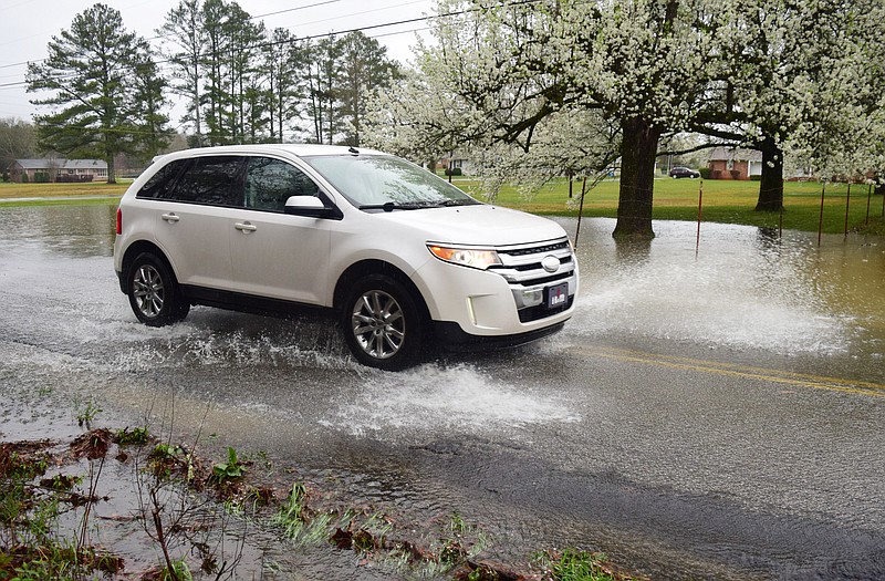 Staff Photo by Robin Rudd / A car splashes through a area of ponded water on Davidson Road in East Brainerd on March 16, 2021. According to WRCB Weather there is a 95 percent chance of rain today (Wednesday) and the possibility of storms.
