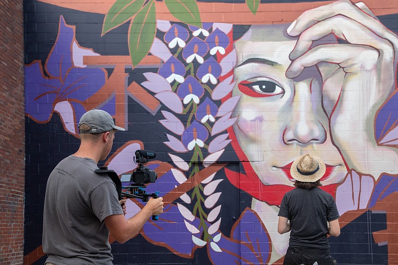 Contributed Photo from Kristin Luna / Filmmaker Colin Shuran, left, on Saturday will premiere "Walls for Women," a documentary he made about a Tennessee mural project of the same name that pays tribute to the women's suffrage movement. Here he films Tokyo-born, Oklahoma-based artist Juuri as she paints "Wisteria Maiden" on the backside of Memories Antiques in downtown Tullahoma, Tenn.