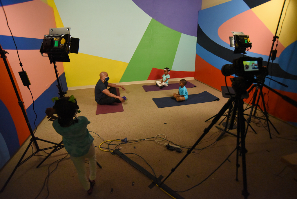 Staff Photo by Matt Hamilton / UTC student Johnny Martin talks to Deyani Morgan, 5, and Evan Penn, 4, on the mats as JoHari Nichols, 5, left, listens as well, before filming an educational lesson about yoga at WTCI in Chattanooga on Wednesday, March 17, 2021. at WTCI in Chattanooga on Wednesday, March 17, 2021.