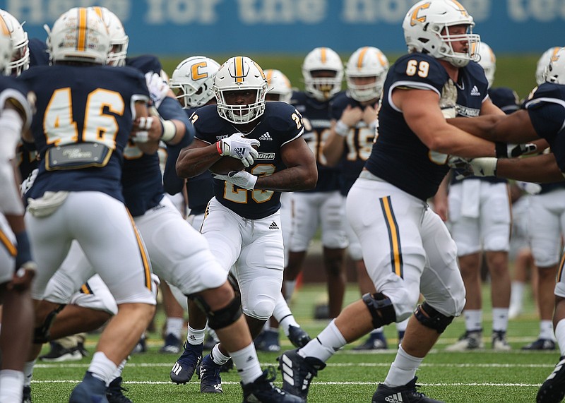 Staff photo by Troy Stolt / UTC running back Tyrell Price, at center with ball, warms up before the Mocs' SoCon opener against Wofford on Feb. 27 at Finley Stadium.