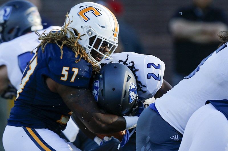 Staff photo by C.B. Schmelter / Sweat flies as UTC linebacker Kam Jones (57) hits Eastern Illinois running back Courtney Rowell during the 2019 season opener at Finley Stadium.