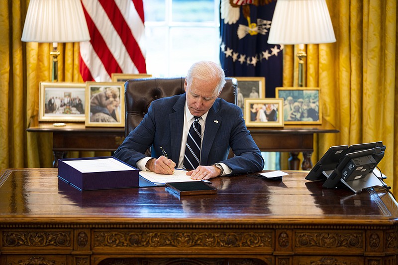 New York Times file photo by Doug Mills / President Joe Biden signs the "American Rescue Plan" in the Oval Office of the White House on March 11. Attorneys General in 21 GOP states want to use the aid for tax cuts.