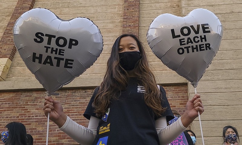 FILE - In this March 13, 2021, file photo, Chinese-Japanese American student Kara Chu, 18, holds a pair of heart balloons decorated by herself for the rally "Love Our Communities: Build Collective Power" to raise awareness of anti-Asian violence outside the Japanese American National Museum in Little Tokyo in Los Angeles. Asian Americans, already worn down by a year of racist attacks fueled by the pandemic, are reeling but trying to find a path forward in the wake of the horrific shootings at three Atlanta-area massage businesses that left eight people dead, most of them Asian women. (AP Photo/Damian Dovarganes, File)

