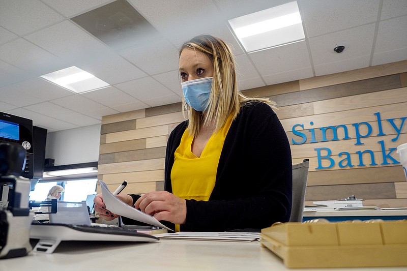 Staff photo by C.B. Schmelter / Teller Kayla Holloway works at the counter at SimplyBank on Monday, March 15, 2021 in Dayton, Tenn. Rhea County's biggest banks, Community National Bank and SimplyBank, are combining operations and offices this weekend and will reopen Monday morning as a single bank under the SimplyBank moniker.