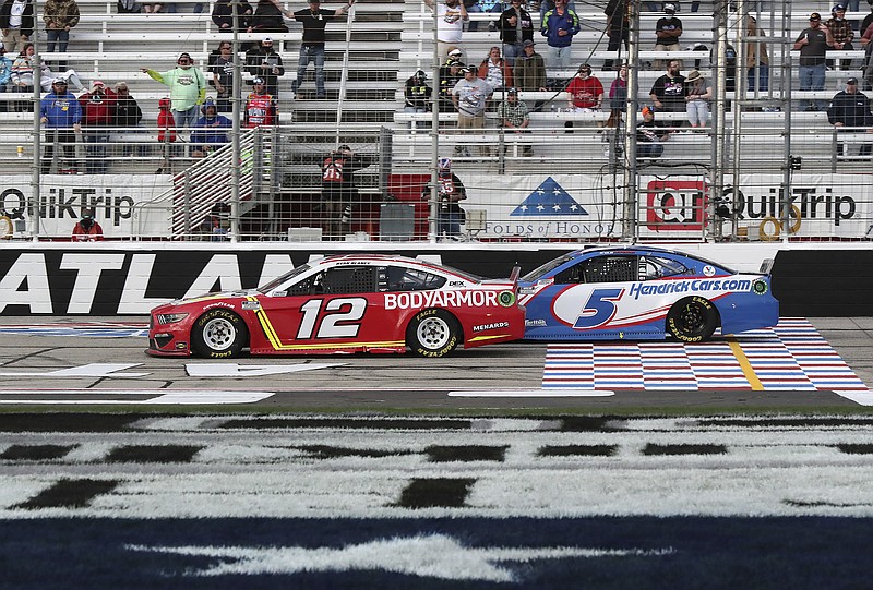 Atlanta Journal-Constitution photo by Curtis Compton via AP / Ryan Blaney (12) passes Kyle Larson with eight laps to go on his way to winning Sunday's NASCAR Cup Series race at Atlanta Motor Speedway in Hampton, Ga.