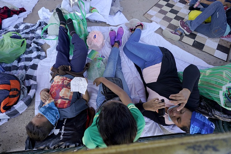 Migrants rest in a gazebo at a park after a large group of deportees were pushed by Mexican authorities off an area they had been staying after their expulsion from the U.S., Saturday, March 20, 2021, in Reynosa, Mexico. A surge of migrants on the Southwest border has the Biden administration on the defensive. The head of Homeland Security acknowledged the severity of the problem Tuesday but insisted it's under control and said he won't revive a Trump-era practice of immediately expelling teens and children. An official says U.S. authorities encountered nearly double the number children traveling alone across the Mexican border in one day this week than on an average day last month. (AP Photo/Julio Cortez)