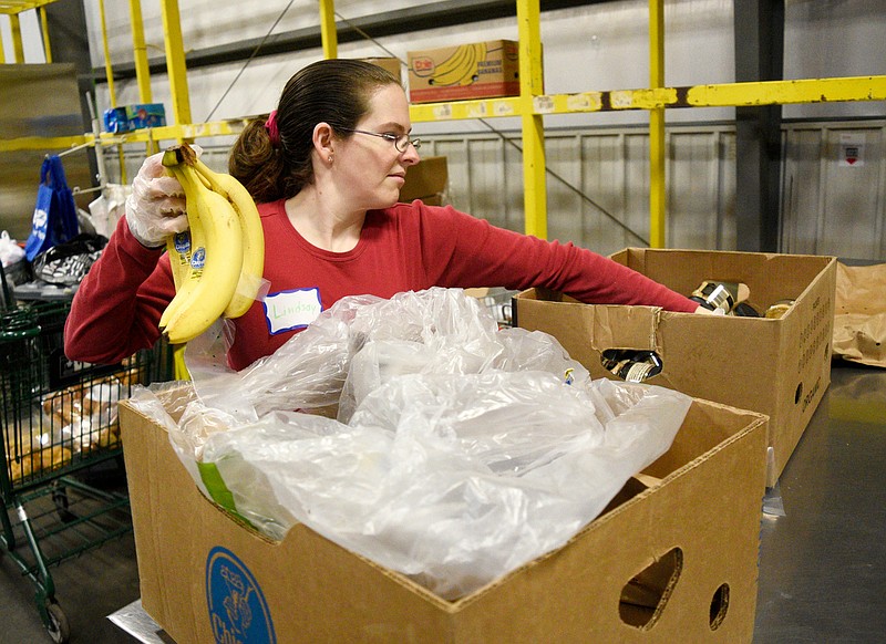 Staff Photo by Robin Rudd / Chattanooga Food Bank volunteer Lindsay Davidson stocks an emergency food box in March 2020. The food bank will host five food distributions across the Chattanooga region for those facing food insecurity amid the pandemic on March 27, 2021.