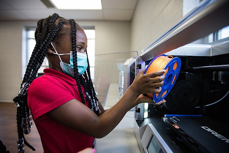 Staff photo by Troy Stolt / Kali McReynolds, 6, holds up materials used inside of Brown Academy's new 3D printers on Monday, March 22, 2021 in Chattanooga, Tenn. Brown Academy is one of seven schools who will be given funding to create an eLab for their students, after a recent donation to the Chattanooga Public Education Fund.