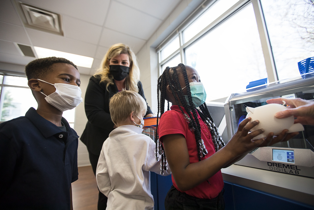 Staff photo by Troy Stolt / Kali McReynolds, 6, right, and Jeremy 6, left, are shown a 3D-printed pig by Hamilton County School District innovation coach Jessica Holloway, not pictured, as Brown Academy Innovations specialist Nikki Russell, top center, shows Kaemon Baecker, 6, one of the new 3D printers at Brown Academy on Monday, March 22, 2021 in Chattanooga, Tenn. Brown Academy is one of seven schools who will be given funding to create an eLab for their students, after a recent donation to the Chattanooga Public Education Fund.