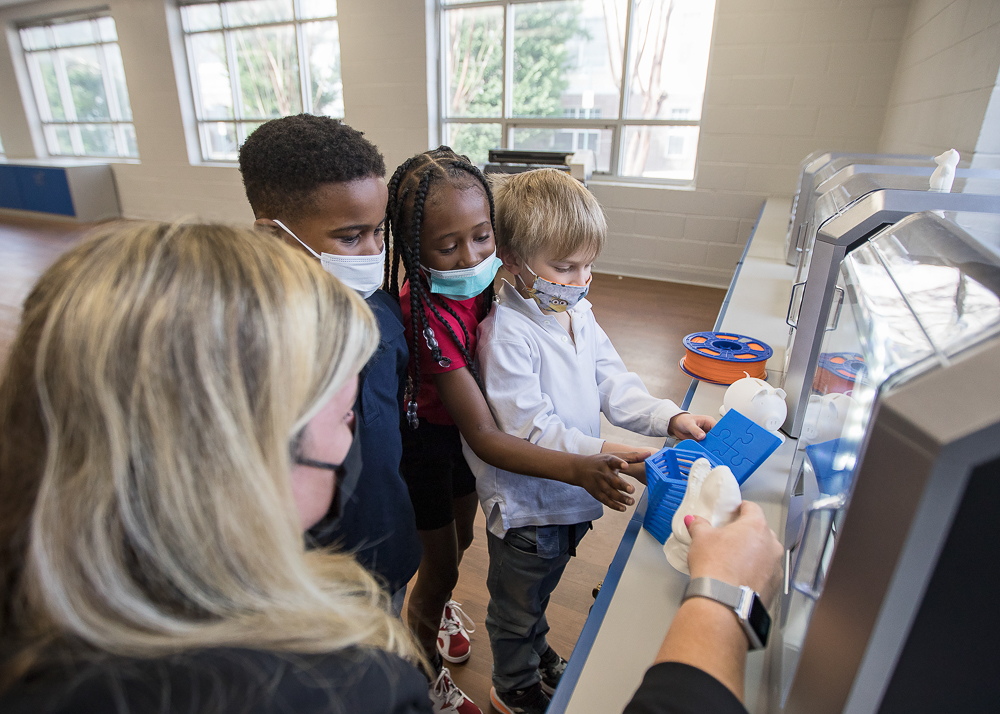Staff photo by Troy Stolt / Nikki Russell, an innovations specialist at Brown Academy, shows Jeremy Young, 6, Kali McReynolds, 6, and Kaemon Baecker, 6, a 3D-printed object on Monday, March 22, 2021 in Chattanooga, Tenn. Brown Academy is one of seven schools who will be given funding to create an eLab for their students, after a recent donation to the Chattanooga Public Education Fund.
