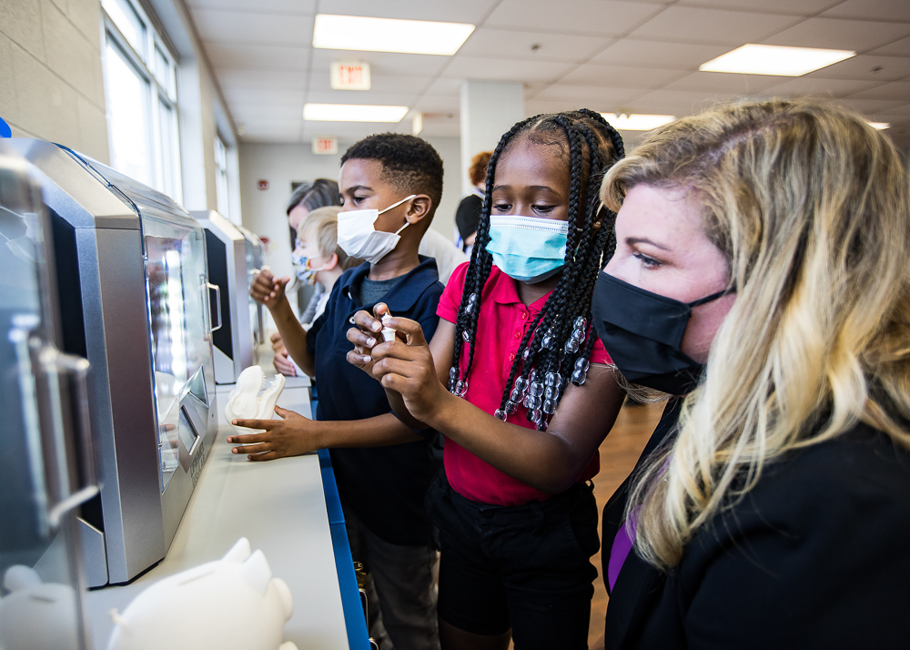 Staff photo by Troy Stolt / Nikki Russell, an innovations specialist at Brown Academy, right, shows Kali McReynolds, 6, and Jeremy Young, 6, the schools new 3D printers on Monday, March 22, 2021 in Chattanooga, Tenn. Brown Academy is one of seven schools who will be given funding to create an eLab for their students, after a recent donation to the Chattanooga Public Education Fund.