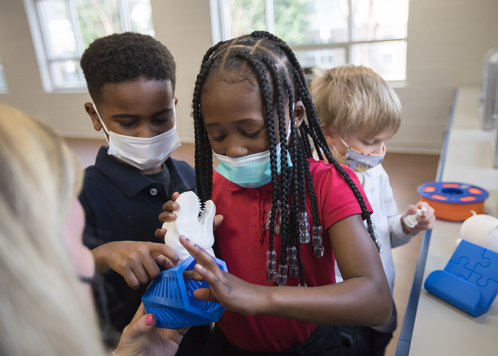 Staff photo by Troy Stolt / Nikki Russell, an innovations specialist at Brown Academy, shows Jeremy Young, 6, Kali McReynolds, 6, and Kaemon Baecker, 6, a 3D-printed object on Monday, March 22, 2021 in Chattanooga, Tenn. Brown Academy is one of seven schools who will be given funding to create an eLab for their students, after a recent donation to the Chattanooga Public Education Fund.