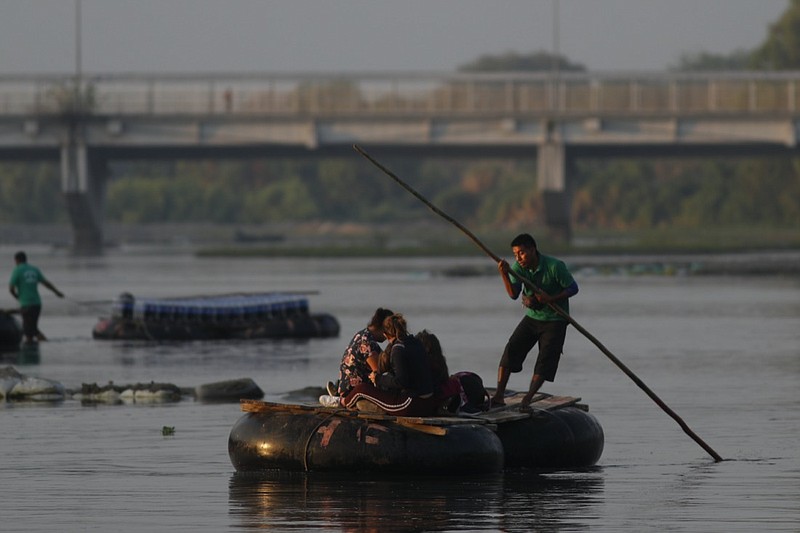 Guatemalan travelers cross the Suchiate River, border between Guatemala and Mexico, into Mexico aboard a raft near Ciudad Hidalgo, Sunday, March 21, 2021. Mexico sent hundreds of immigration agents, police and National Guard officers marching through the streets of the capital of the southern state of Chiapas to launch an operation to crack down on migrant smuggling. (AP Photo/Eduardo Verdugo)

