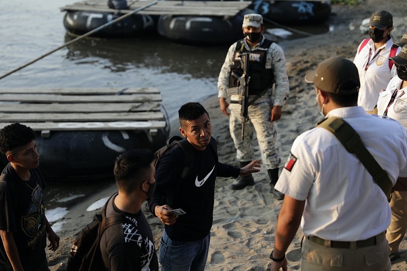 Mexican immigration agents stop people who crossed the Suchiate River, the natural border between Guatemala and Mexico, to see their identification documents as they enforce limits on all but essential travel near Ciudad Hidalgo, Mexico, Monday, March 22, 2021. Agents are forcing those with permission to enter Mexico for work or a visit to use the official border crossing bridge, and those who do not are being returned to Guatemala. (AP Photo/Eduardo Verdugo)