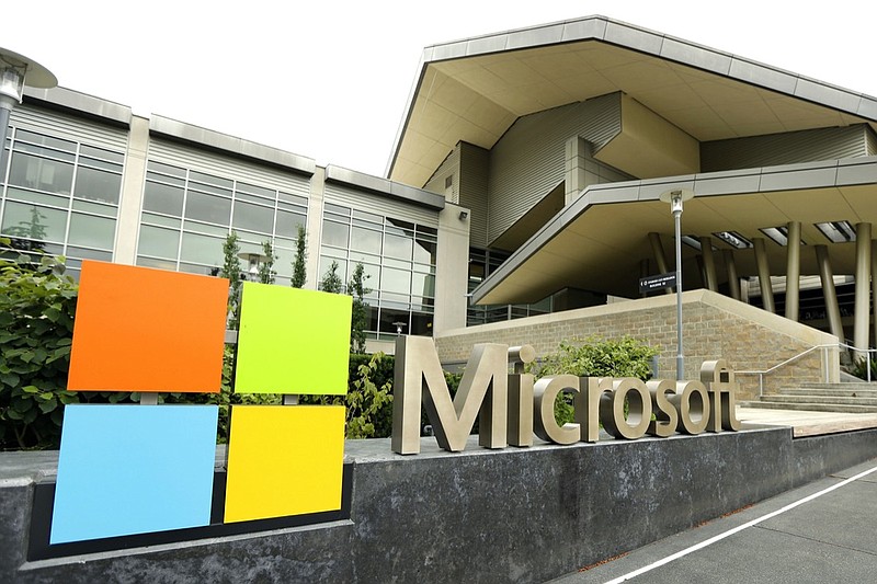 FILE - In this July 3, 2014, file photo, the Microsoft Corp. logo is displayed outside the Microsoft Visitor Center in Redmond, Wash. Microsoft will begin bringing workers back to its suburban Seattle global headquarters on March 29, 2021, as the tech giant starts to reopen more facilities it largely shuttered during the coronavirus pandemic. (AP Photo/Ted S. Warren, File)