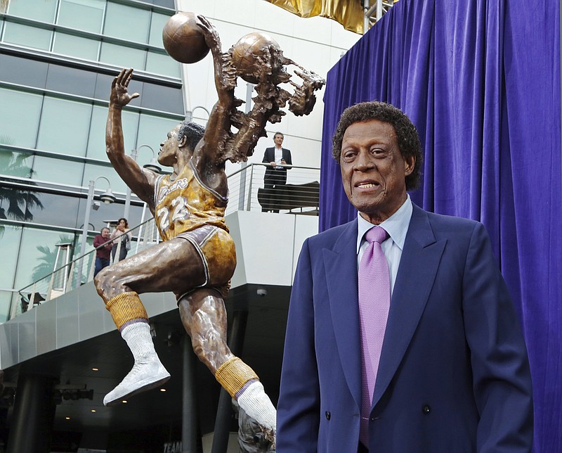 Elgin Baylor stands next to a statue, just unveiled, honoring the Minneapolis and Los Angeles Lakers great, outside Staples Center in Los Angeles, in this Friday, April 6, 2018, file photo. Elgin Baylor, the Lakers' 11-time NBA All-Star, died Monday, March 22, 2021, of natural causes. He was 86. The Lakers announced that Baylor died in Los Angeles with his wife, Elaine, and daughter Krystal by his side. (AP Photo/Reed Saxon, File)