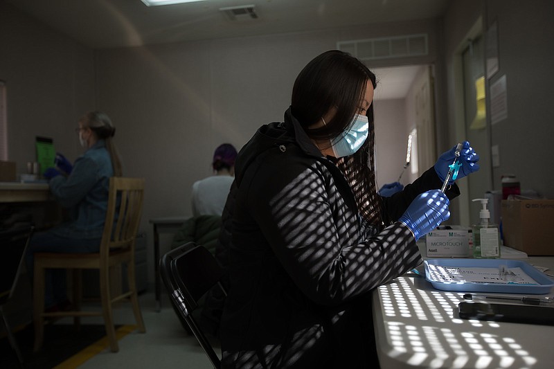 Staff photo by Troy Stolt / Cheryl Newman, a nurse trainer for the Hamilton County Health Department, fills syringes with the Pfizer COVID-19 vaccine in the pharmacy area of the Health Departmentճ Enterprise South COVID Vaccination POD on Wednesday, March 3, 2021 in Chattanooga, Tenn.