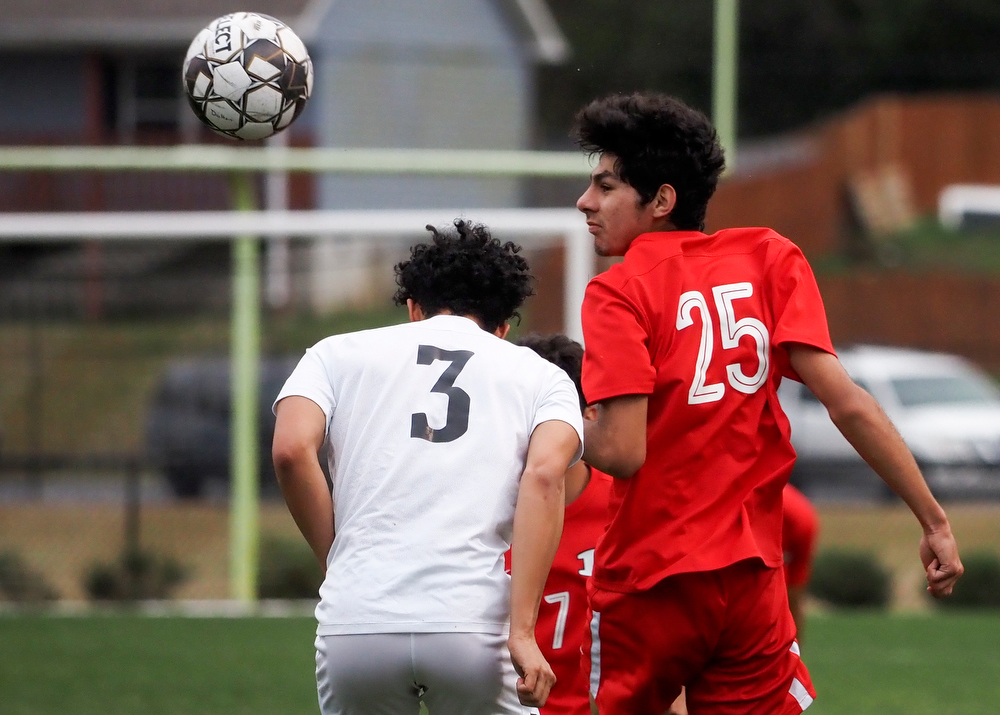 Staff photo by C.B. Schmelter / Dalton's Fabian Rodriguez (25) heads the ball against defense from Carrollton's Nathan Upson (3) on Harmon Field at Bill Chappell Stadium on Tuesday, March 23, 2021 in Dalton, Ga.