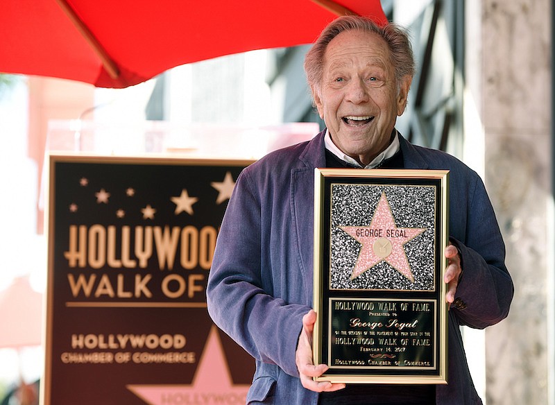 Actor George Segal poses with a replica of his star at a ceremony honoring him on the Hollywood Walk of Fame in Los Angeles on Feb. 14, 2017. Segal, the banjo player turned actor who was nominated for an Oscar for 1966's "Who's Afraid of Virginia Woolf?," and starred in the ABC sitcom "The Goldbergs," died Tuesday, his wife said. He was 87. (Photo by Chris Pizzello/Invision/AP, File)