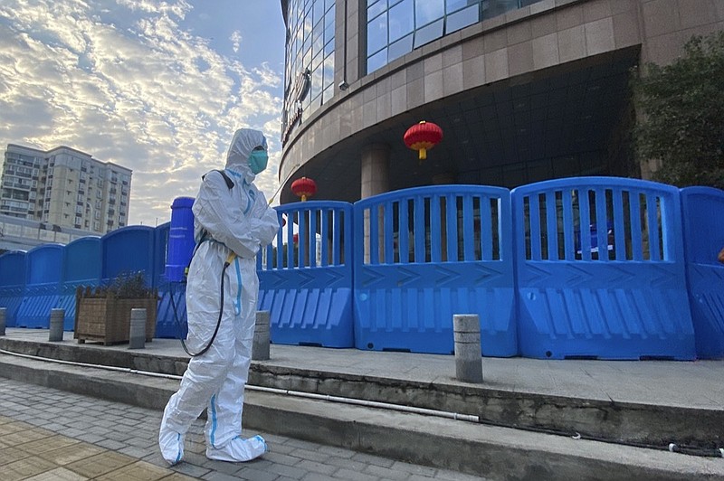 FILE - In this file photo dated Saturday, Feb. 6, 2021, a worker in protectively overalls and carrying disinfecting equipment walks outside the Wuhan Central Hospital where Li Wenliang, the whistleblower doctor who sounded the alarm and was reprimanded by local police for it in the early days of Wuhan's pandemic, worked in Wuhan in central China. (AP Photo/Ng Han Guan, FILE)


