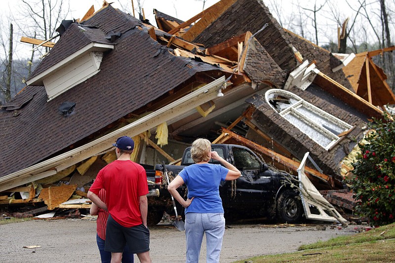 Residents survey damage to homes after a tornado touched down south of Birmingham, Ala. in the Eagle Point community damaging multiple homes, Thursday, March 25, 2021. Authorities reported major tornado damage Thursday south of Birmingham as strong storms moved through the state. The governor issued an emergency declaration as meteorologists warned that more twisters were likely on their way. (AP Photo/Butch Dill)