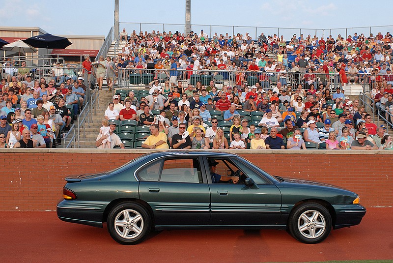 Staff photo / A Pontiac Bonneville parades before the fans during the Chattanooga Lookouts' "Used Car Night" promotion in August 2009 at AT&T Field. The minor league baseball team's annual promotion in which multiple vehicles are given away during a single game has been expanded this season to present one at each Saturday night home game during the 2021 season.