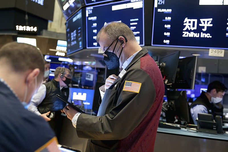 In this photo provided by the New York Stock Exchange, William Lawrence, center, works with fellow traders on the floor, Friday, March 26, 2021. Stocks rose in afternoon trading on Wall Street Friday with technology companies and banks leading the way higher. (Nicole Pereira/New York Stock Exchange via AP)