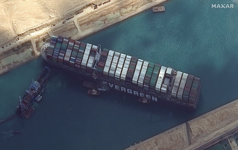 This satellite image from Maxar Technologies shows the cargo ship MV Ever Given stuck in the Suez Canal near Suez, Egypt, Friday, March 26, 2021. A maritime traffic jam grew to more than 200 vessels Friday outside the Suez Canal and some vessels began changing course as dredgers worked frantically to free a giant container ship that is stuck sideways in the waterway and disrupting global shipping. (©Maxar Technologies via AP)