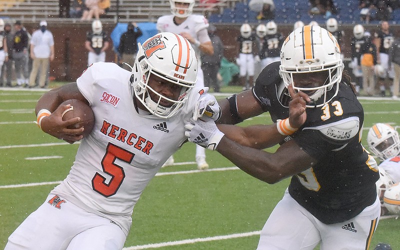 Staff photo by Matt Hamilton / Mercer's Fred Davis carries the ball as he tries to push UTC's Zay Brown away during Saturday's SoCon game at Finley Stadium.