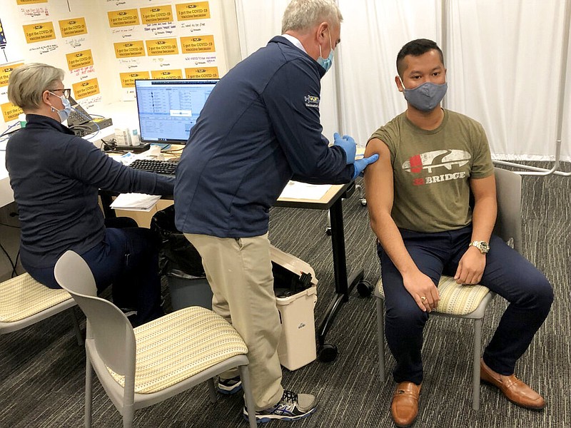 U.S. Rep. Brad Wenstrup, R-Ohio administers a COVID-19 vaccine to Eli Livingston with the aid of a doctor, left, at TriHealth clinic, in Norwood, Ohio, on Sunday, March 28, 2021. (AP Photo/Dan Sewell)
