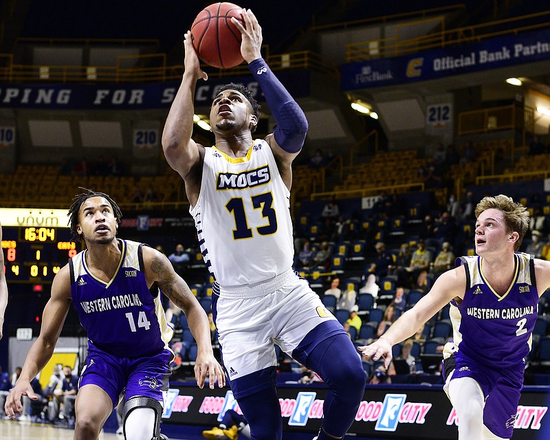 Staff Photo by Robin Rudd /  Chattanooga's Malachi Smith (13) drives to the basket past Western's Kameron Gibson (14) and Matt Halversen (2).  The University of Tennessee at Chattanooga Mocs hosted the Western Carolina Catamounts in men's Southern Conference basketball at McKenzie Arena on February 17, 2021.