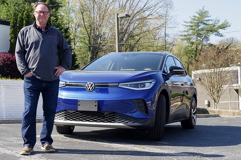Staff photo by C.B. Schmelter / Mike Purcell stands in front of his Volkswagen ID.4 at his office at Re/Max Renaissance Realtors last week in Chattanooga. Purcell is one of the first in the city to own the electric SUV.
