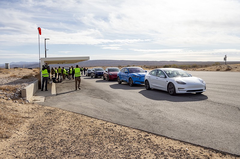 This undated photo by Edmunds shows five electric vehicles at a test track in the Mojave Desert, in California, undergoing testing for maximum range. (Scott Jacobs/Edmunds via AP)