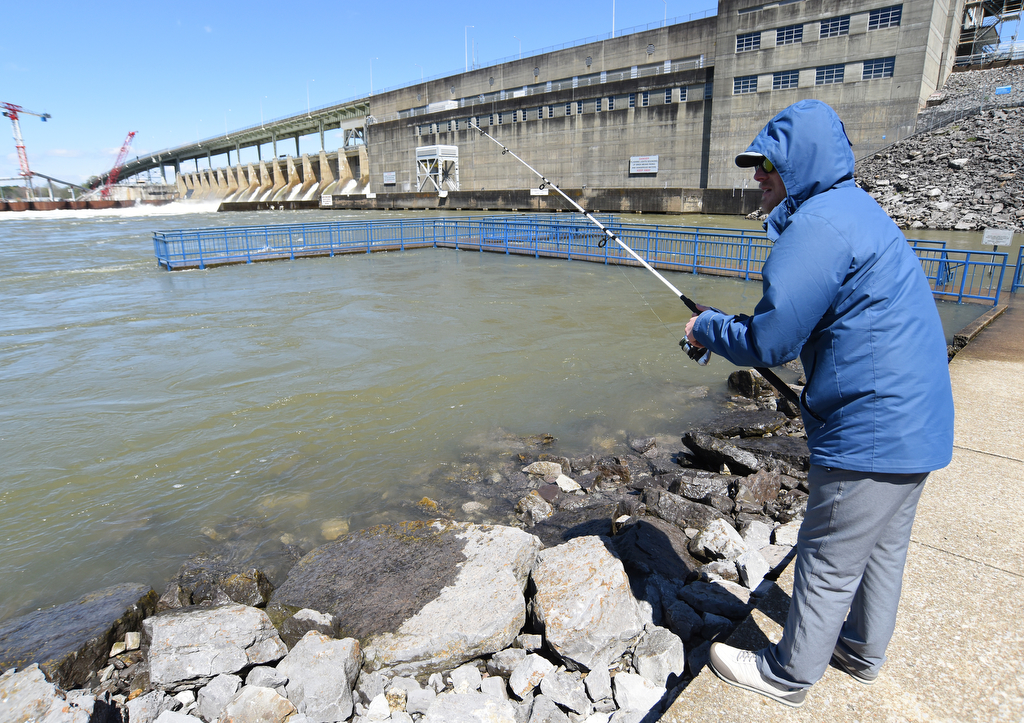 Staff Photo by Matt Hamilton / Flintstone, Ga. resident Russ Young fishes beside the partially-covered pier at the Chickamauga Dam on Thursday, April 1, 2021.